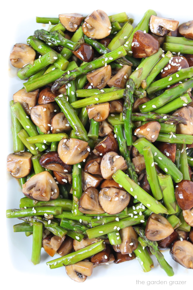 Asian-style mushroom and asparagus stir fry on a white plate