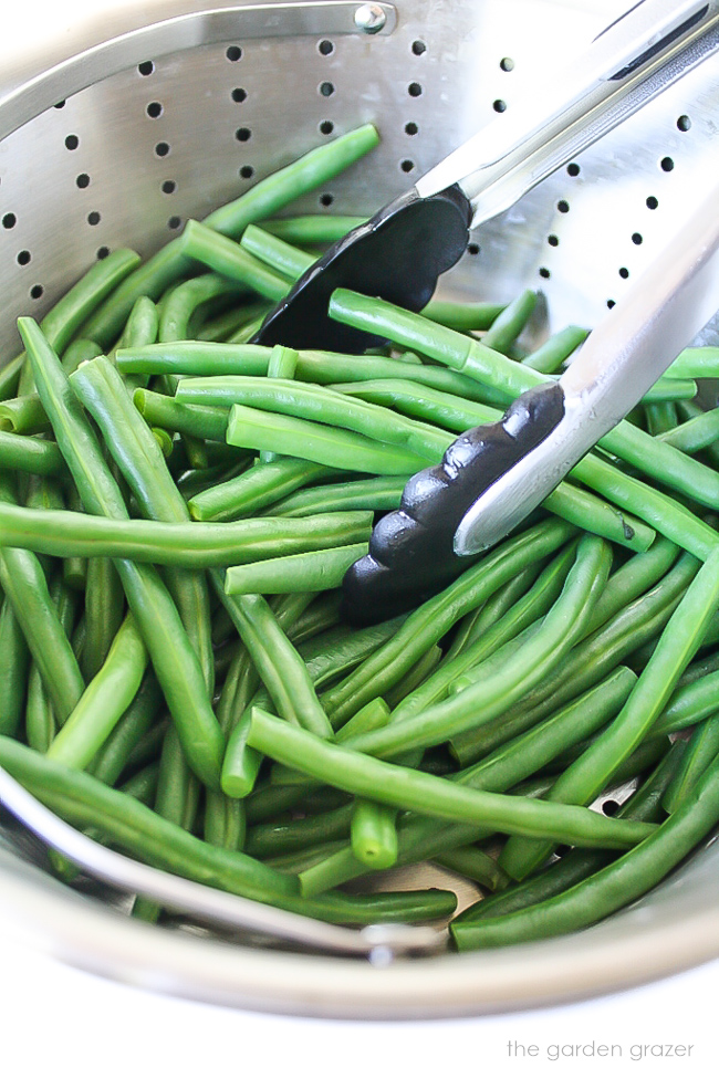Cooked green beans in a steamer pan