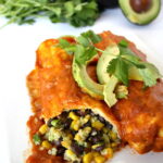 Black bean and avocado enchiladas with homemade sauce on a plate