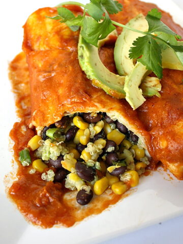 Black bean avocado enchiladas on a white plate