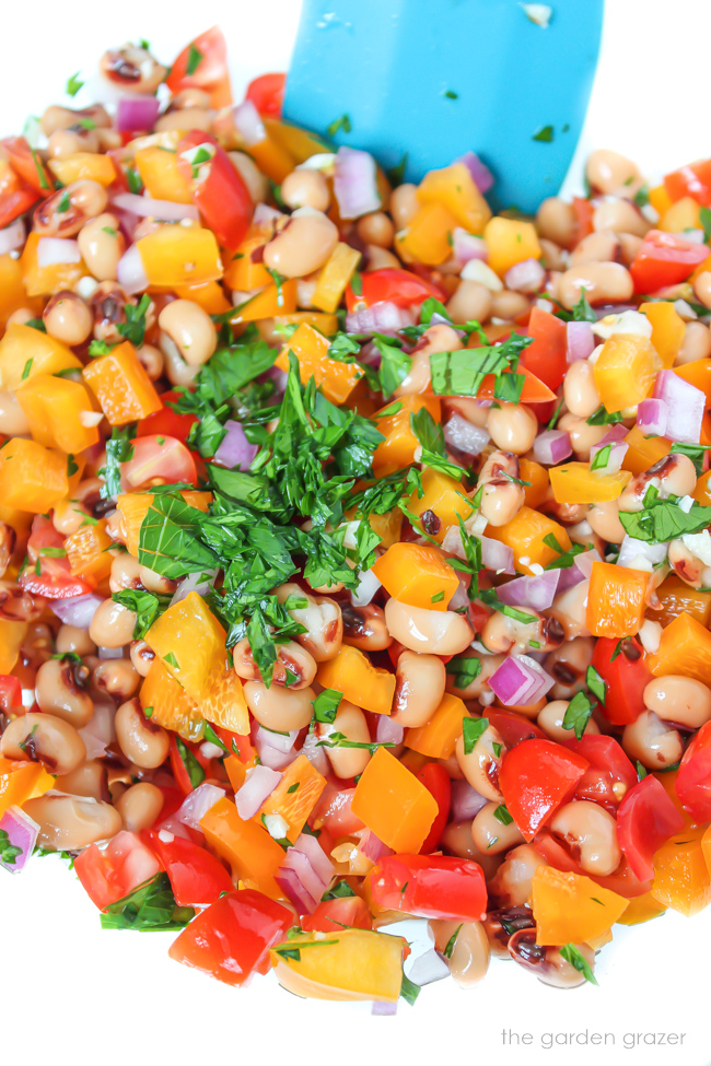 Black Eyed Pea salad being mixed together in a bowl