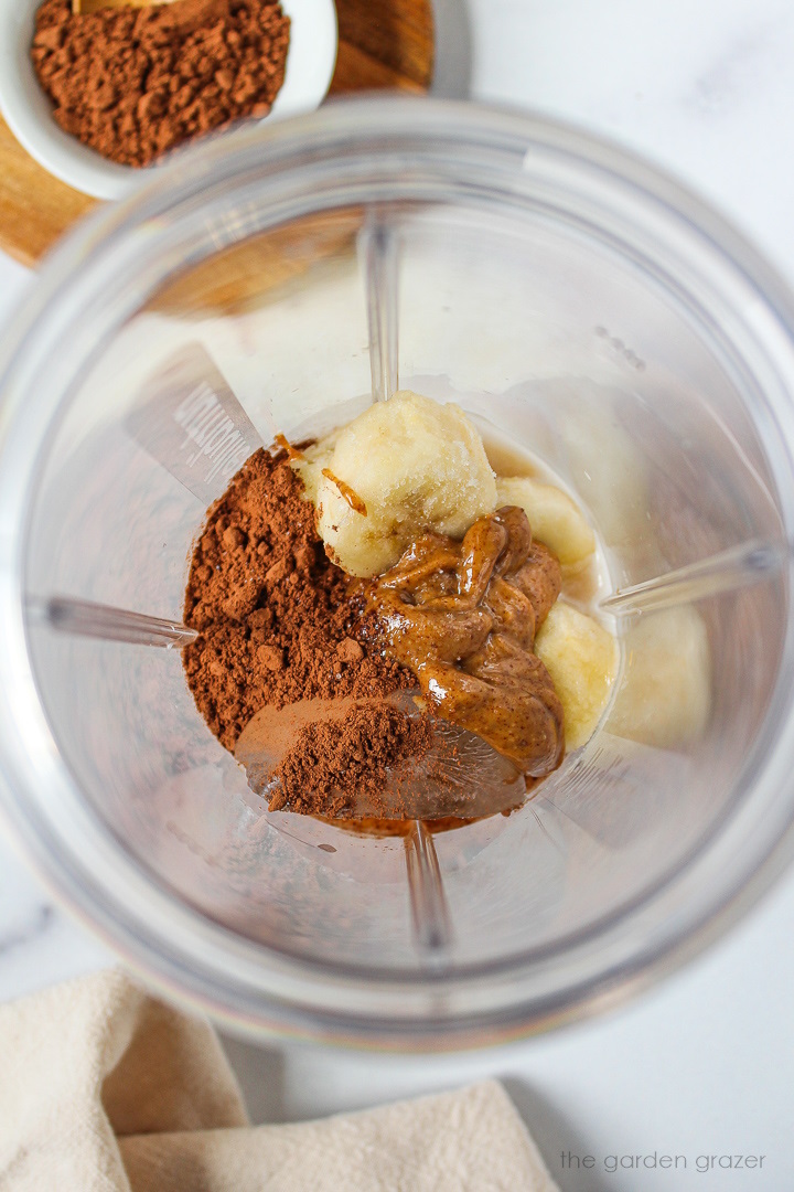 Overhead view of preparing milkshake ingredients in a small blender cup before blending