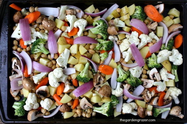 Sheet pan preparation of assorted raw vegetables waiting to be roasted