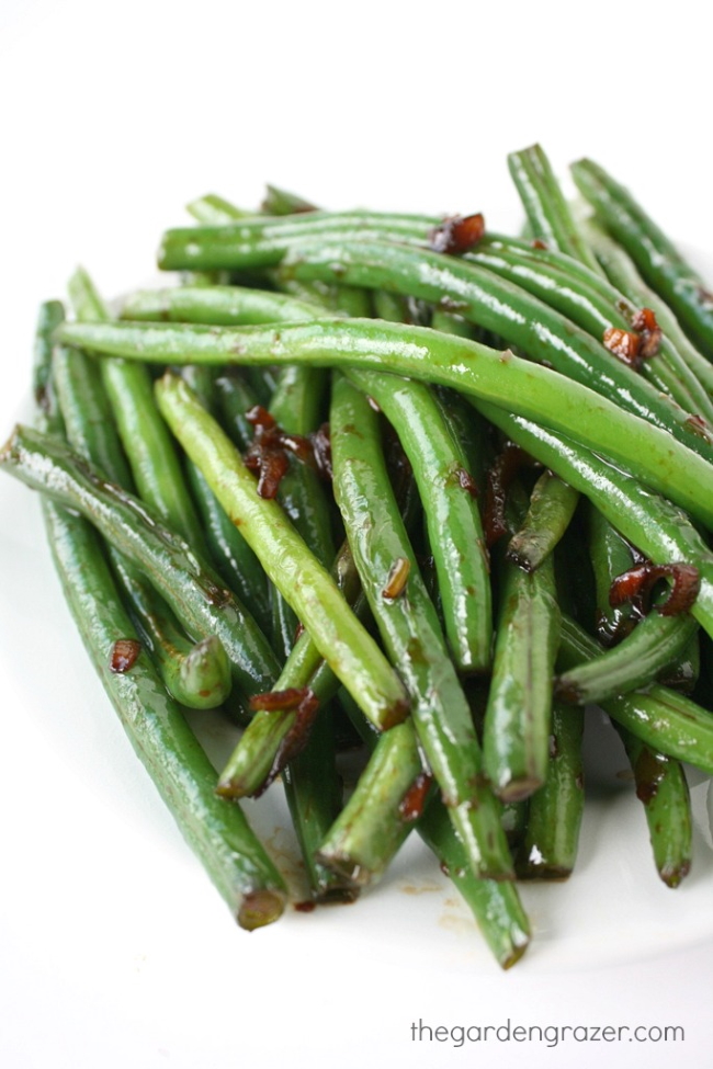 Asian-style garlic green beans on a white plate