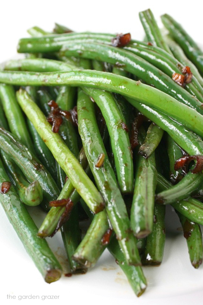 Asian-style garlic green beans on a white plate