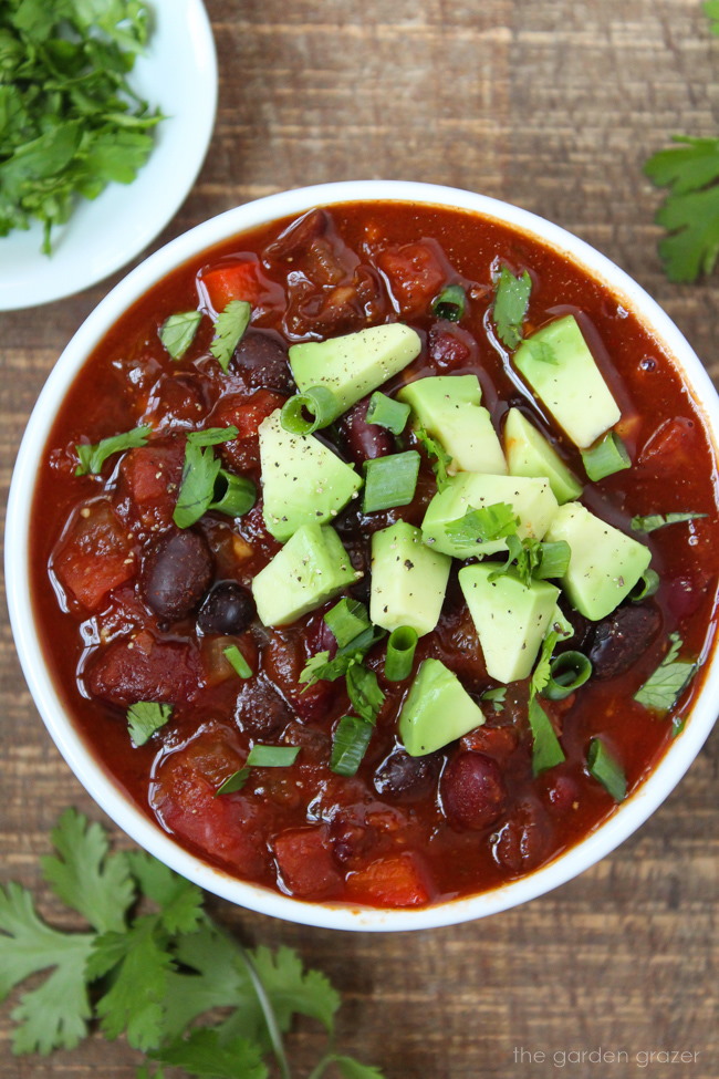 Small white bowl with bean chili on a wooden table