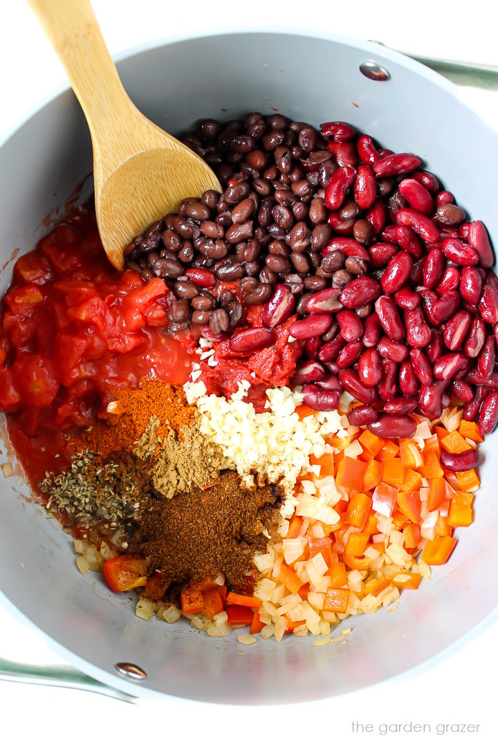 Overhead view of preparing chili ingredients in a pot before stirring together