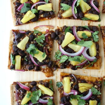 Vegan Hawaiian BBQ pizza with black beans on a cutting board