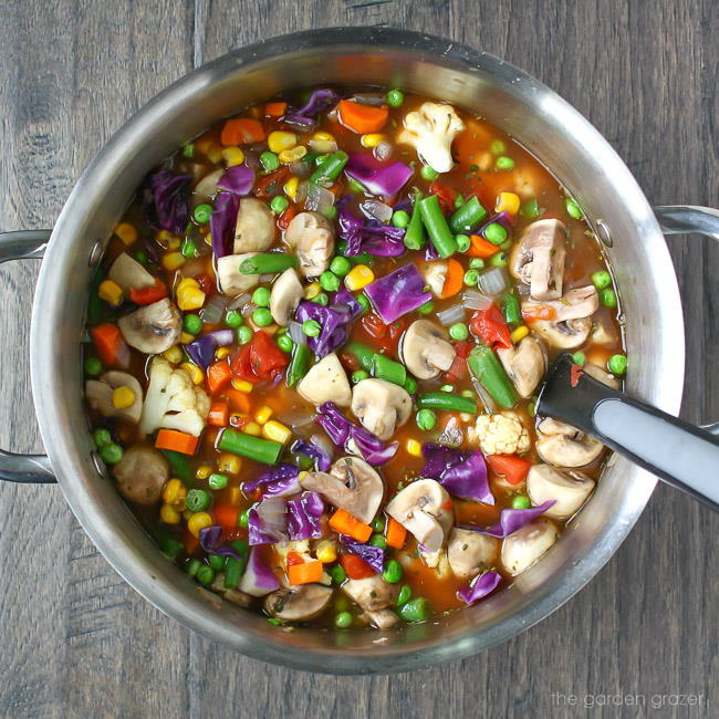 Vegan veggie soup in a big pot with spoon