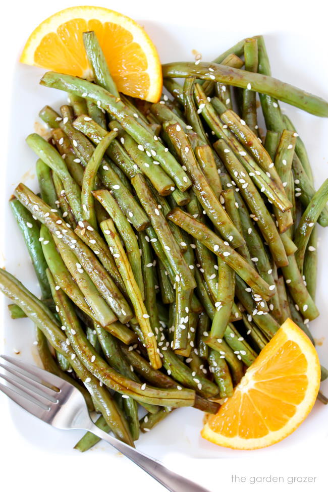 Hoisin green beans on a plate with oranges