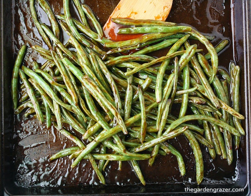 Hoisin roasted green beans on a sheet pan with wooden spatula