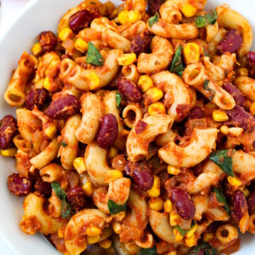 Overhead view of vegan chili mac on a white serving plate with fork