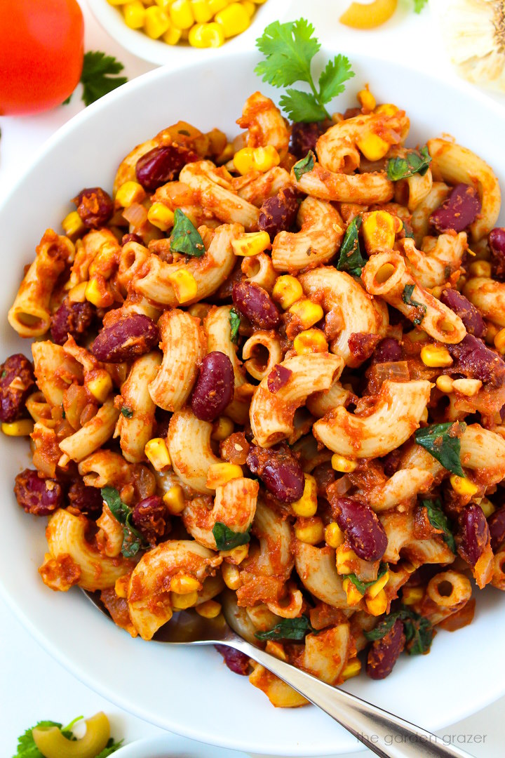 Overhead view of vegan chili mac on a white serving plate with fork