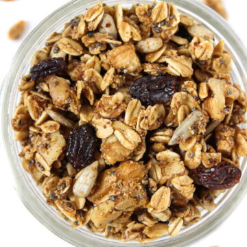 Overhead view of an open glass jar of granola with raisins