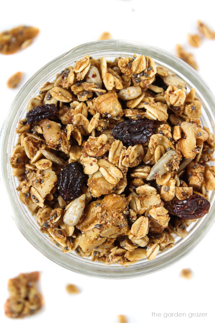 Overhead view of an open glass jar of granola with raisins