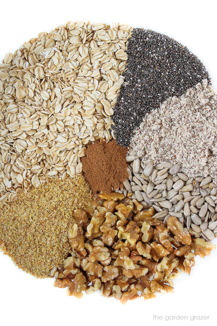Separate ingredients laid out in a large glass bowl for nut and seed granola