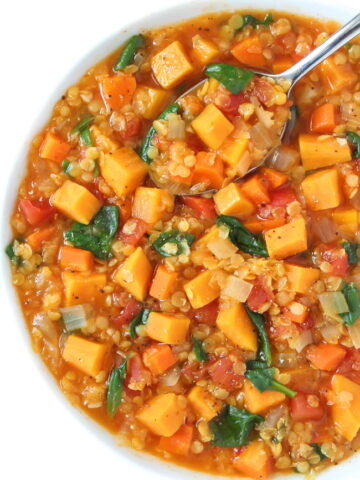 Bowl of vegan red lentil sweet potato stew with spoon