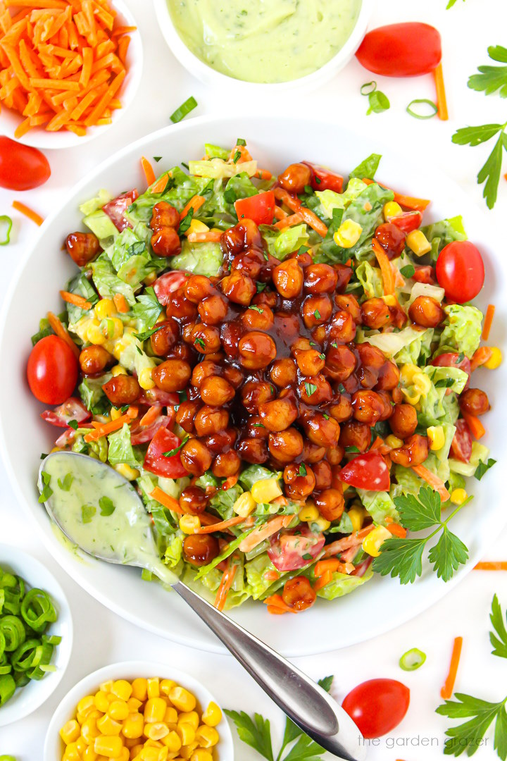 Overhead view of vegan BBQ chickpea chopped salad with avocado ranch dressing and serving spoon