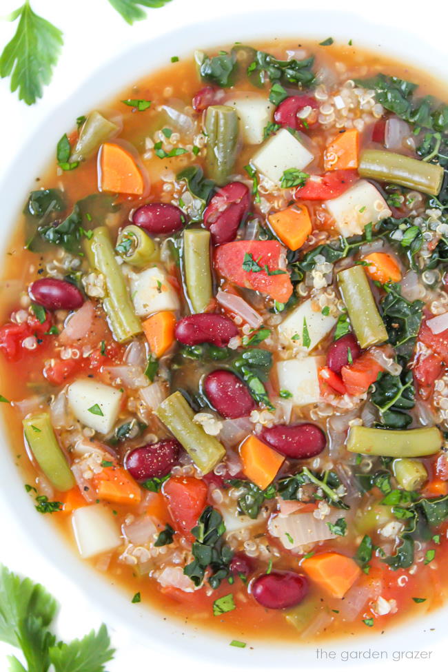 Vegan quinoa minestrone soup with kidney beans in a white bowl