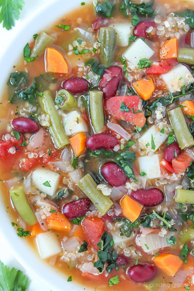 Bowl of vegan quinoa minestrone soup with potatoes and vegetables
