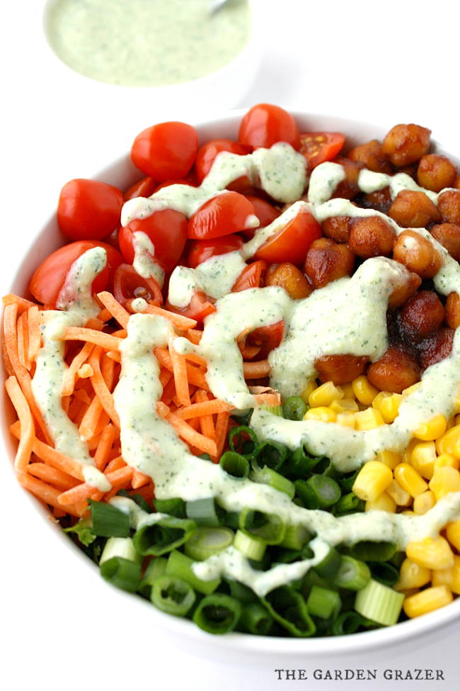 Bowl of BBQ chickpea salad with creamy vegan ranch dressing swirled on top