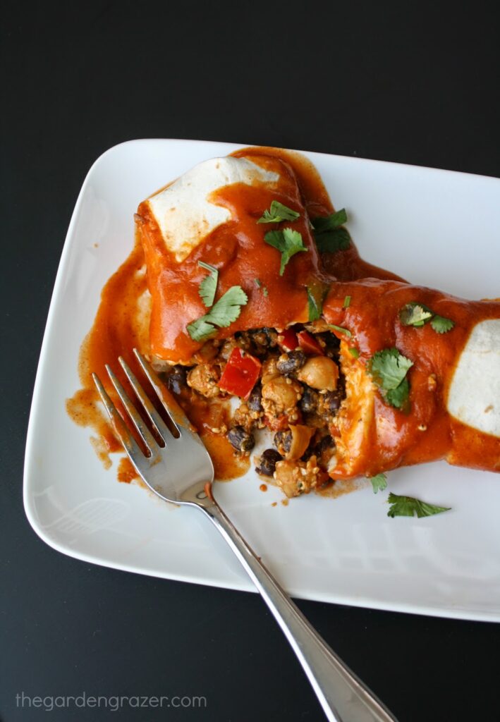 Vegan enchiladas with garbanzos and black beans on a plate with fork
