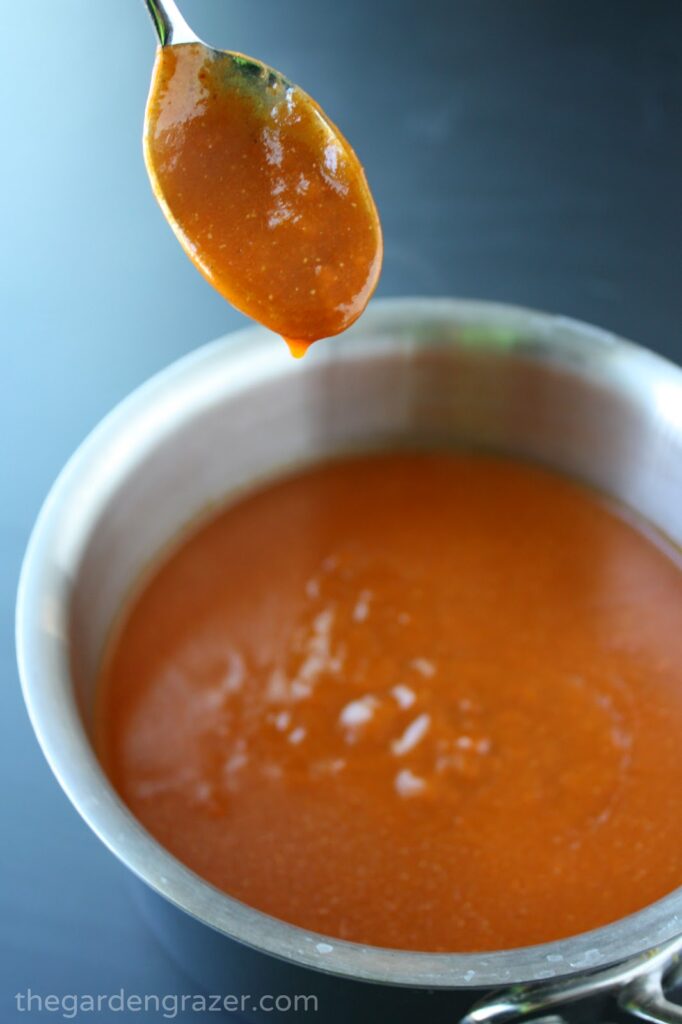 Pan of homemade enchilada sauce with a spoon