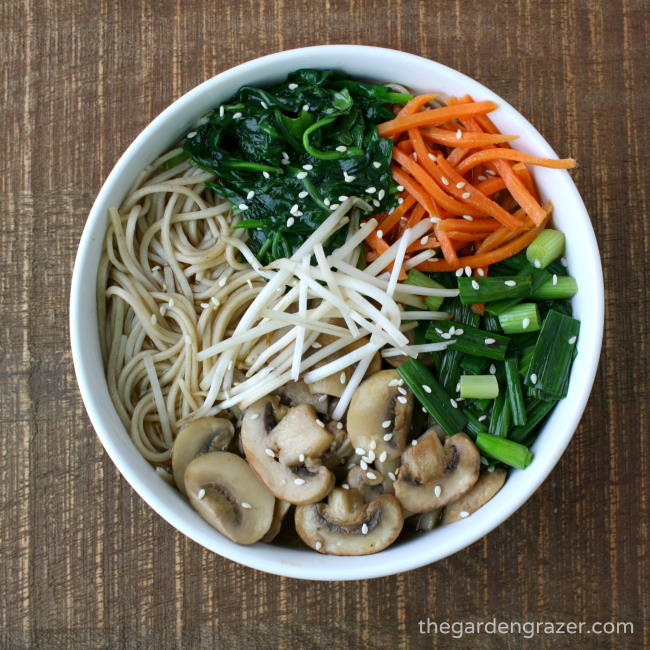 noodle soup in a bowl with bean sprouts, carrots, and mushroom
