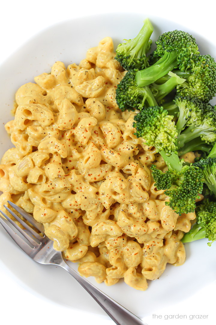 Vegan cashew mac and cheese in a white bowl with broccoli