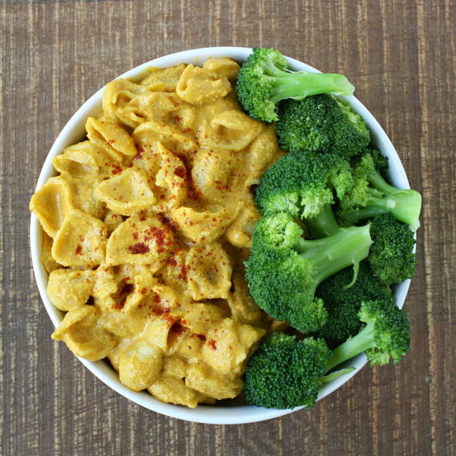 Vegan mac and cheese in a white bowl with broccoli