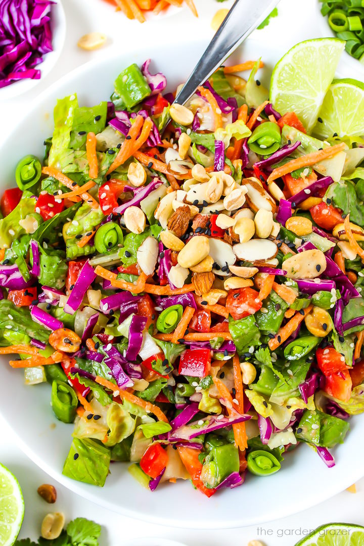 Close up view of Asian Chopped Salad with sesame ginger dressing in a white serving bowl with fork