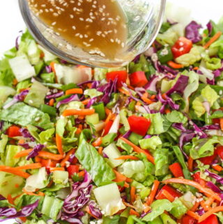 Asian Chopped Salad with sesame dressing being poured on top