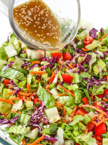 Asian Chopped Salad with sesame dressing being poured on top