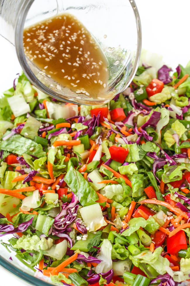 Asian Chopped Salad with sesame dressing being poured on top