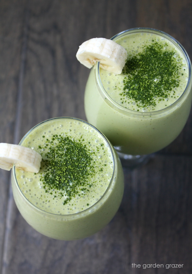Overhead view of two coconut matcha smoothies sprinkled with matcha powder