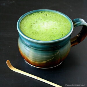 Large mug of vanilla soy matcha latte with bamboo scoop