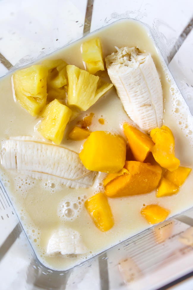ingredients in a blender for creamy tropical smoothie