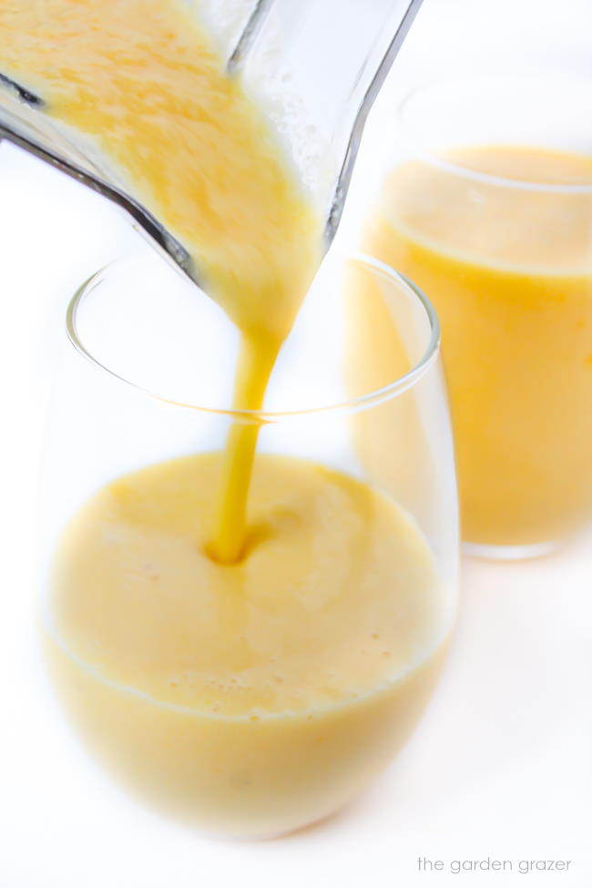 Pouring vegan tropical smoothie into glasses
