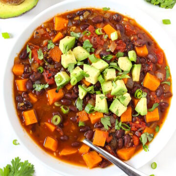 Overhead view of sweet potato black bean chili in a white bowl with spoon