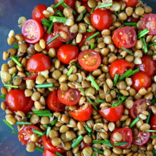 Lentil tomato salad in a bowl with chives