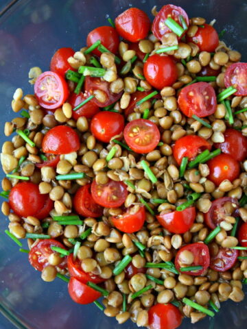 Lentil tomato salad in a bowl with chives