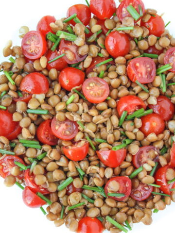 Tomato Lentil Salad tossed together in a bowl with chives