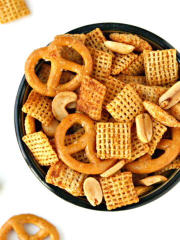 Vegan chex mix in a small bowl on white table