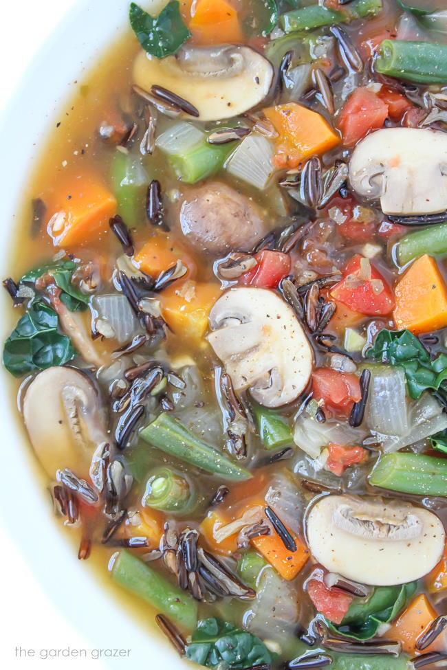 Veggie soup with mushrooms in a white bowl