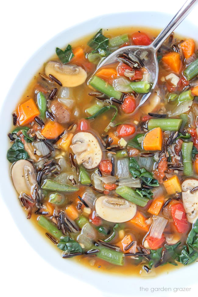 Vegan wild rice vegetable soup in a bowl with spoon