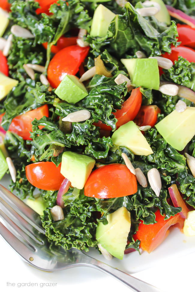 Marinated kale salad with avocado and tomato on a plate