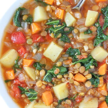 Bowl of vegan lentil kale potato soup with spoon