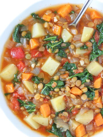 Bowl of vegan lentil kale potato soup with spoon