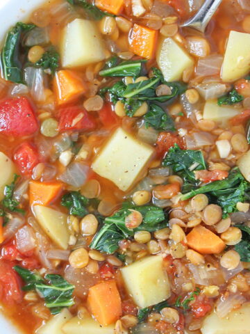 Lentil kale soup in a white bowl