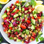 Overhead view of Mediterranean Three Bean Salad on a white plate with serving spoon